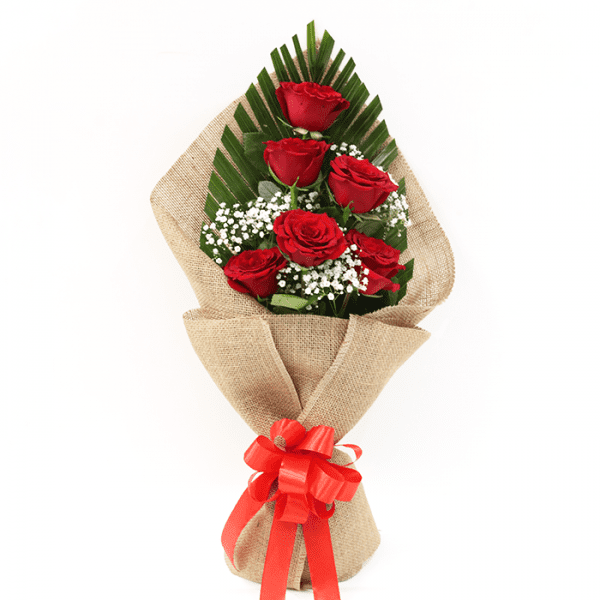 6 red roses bouquet with gypso and green leaves wrapped in jute wrap and tied with a red ribbon.