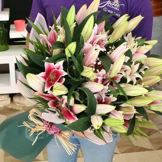 Pink lilies bouquet featuring stargazer oriental lily in elegant floral wrap.
