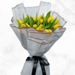 Vibrant Yellow Tulip Bouquet wrapped in a white Cellophane Sheet, making it more sophisticated.