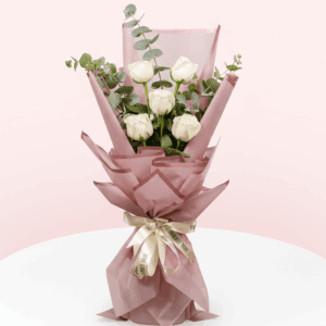 "A bouquet of 5 white roses with eucalyptus and wrapped in a pink korean paper.