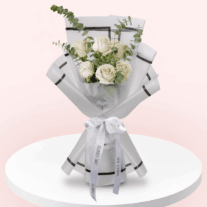 A bouquet of 6 white roses paired with green eucalyptus and wrapped in a white paper