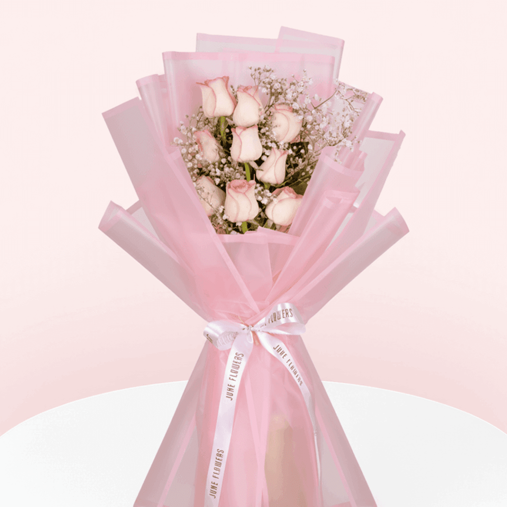 Enjoy this hand-tied 8 pink rose and gypso bouquet wrapped in Korean style flower wrapping sheets with white ribbon