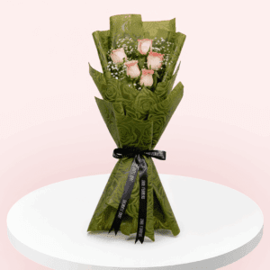 Light pink rose bouquet wrapped in non-woven green color paper