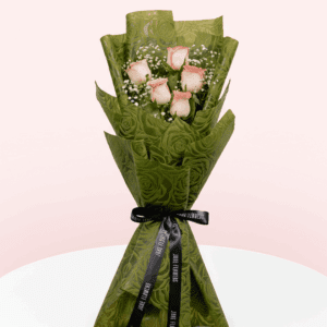 Light pink rose bouquet wrapped in non-woven green color paper