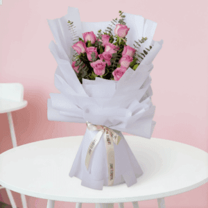 Purple roses bouquet with eucalyptus wrapped in non-woven paper.