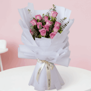 Purple roses bouquet with eucalyptus wrapped in non-woven paper.