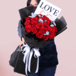 A bouquet of red roses with eucalyptus in a Korean-style black luxury wrap, finished with a “Love for You” message card.