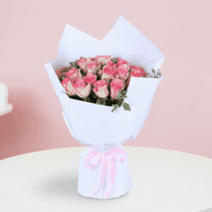A bouquet featuring blush pink roses with green fillers in an elegant white wrap, finished with a soft pink ribbon.