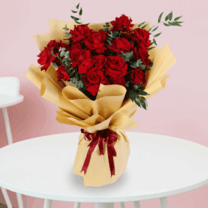 Red roses bouquet with green fillers in a luxury gold wrap, finished with a maroon ribbon.