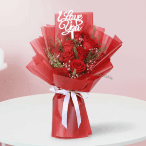 Red roses with delicate white fillers in a red wrap, finished with an “I Love You” message topper.