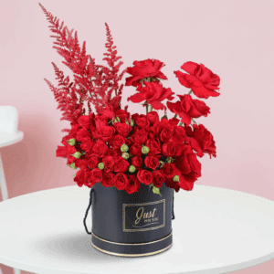 Romantic red roses and astilbe floral arrangement in black box.