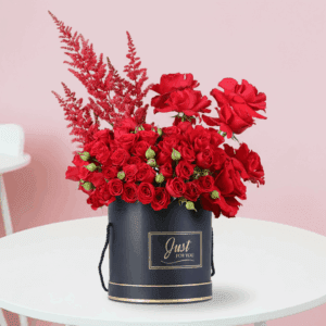 Romantic red roses and astilbe floral arrangement in black box.