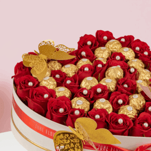 Romantic Valentine flower and chocolate combo featuring red roses and Ferrero Rocher in white heart box.