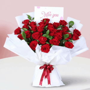 Bouquet of fresh red roses in an elegant white wrap, finished with a “Miss You” message card.