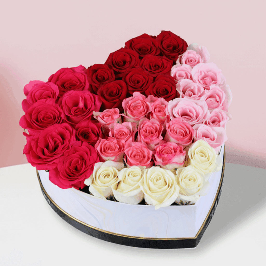 Red, pink, and white roses arranged in a heart-shaped box, finished with a “Love You” message.