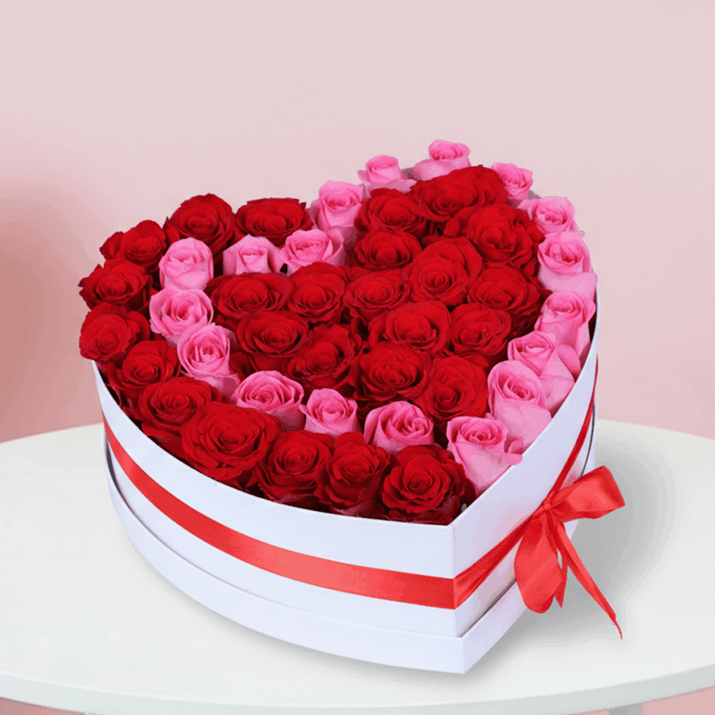 Red and pink roses in a heart-shaped box style, finished with a red ribbon detail.