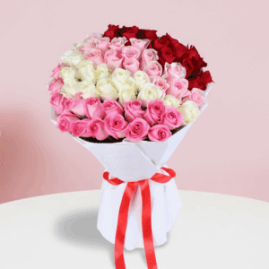 A bouquet of red, pink, and white roses in an elegant white wrap, finished with a red ribbon.
