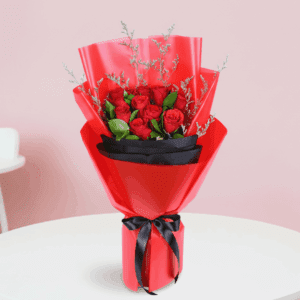 A bouquet of red roses with green fillers in a red and black wrap, finished with a black ribbon.