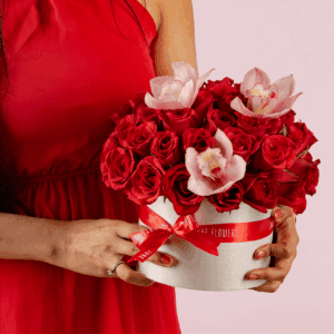 Valentine flower arrangement featuring red roses and white cymbidium in a luxury white round box.