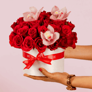 Valentine flower arrangement featuring red roses and white cymbidium in a luxury white round box.