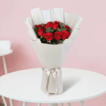 Fresh red roses bouquet wrapped in elegant white non woven paper with white ribbon for Valentine’s Day gifting.