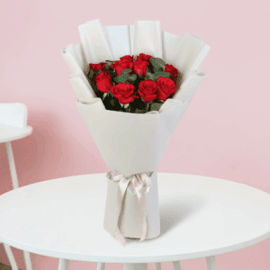 Fresh red roses bouquet wrapped in elegant white non woven paper with white ribbon for Valentine’s Day gifting.