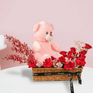 Flower basket with red roses, cymbidium orchids, moss grass and teddy bear in rectangle basket.
