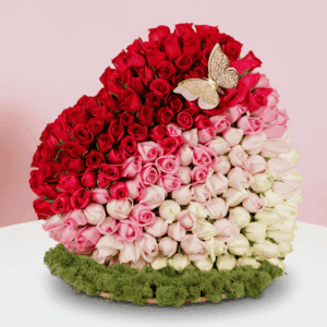 Assorted rose heart arrangement on wooden heart-shaped base with moss grass edging.