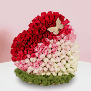 Assorted rose heart arrangement on wooden heart-shaped base with moss grass edging.